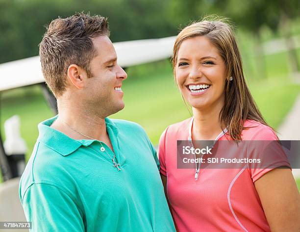 Happy Couple Playing Golf Together On Course Stock Photo - Download Image Now - Females, Golfer, Young Adult
