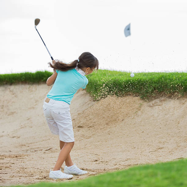 petite fille golfeur frapper balle de golf de bunker - freedom tire swing tire swing photos et images de collection