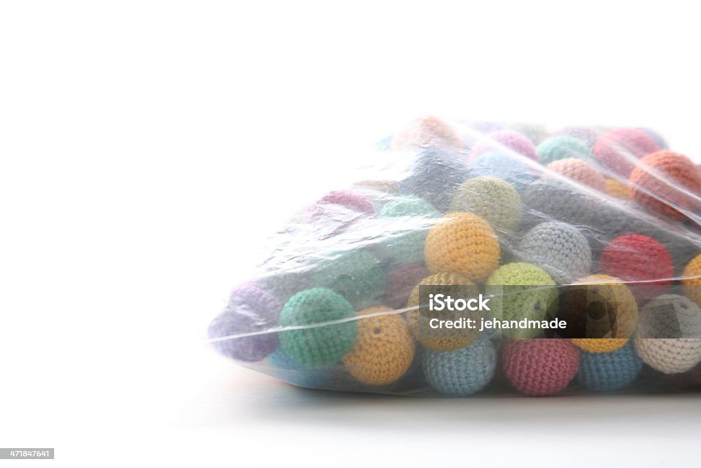 Crochet bolas encapsulados en una bolsa de plástico en blanco mesa - Foto de stock de Abalorio libre de derechos