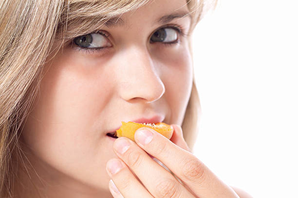istock beautiful girl biting a half apricots 471848751