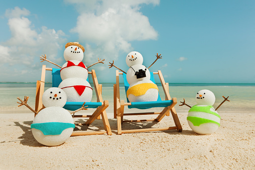 Subject: Tourist snowman family winter vacationing in tropical paradise, sitting in beach chairs in Cancun Mexico.
