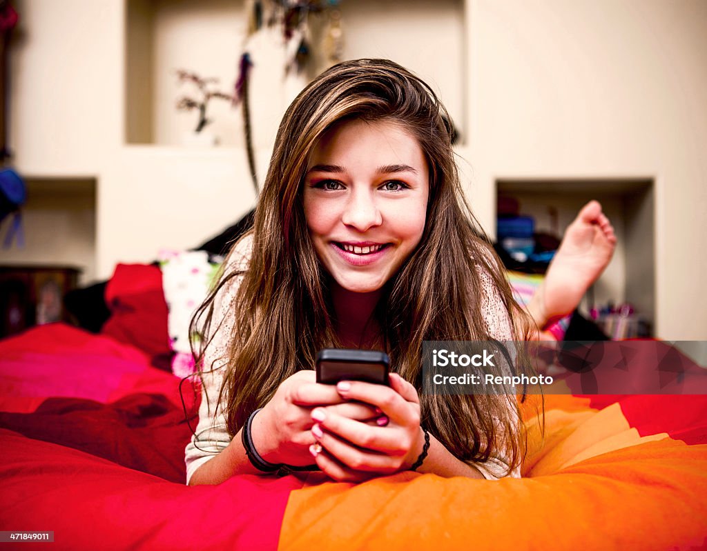 Teenage Girl Texting Teenage Girl Texting on her Phone 14-15 Years Stock Photo