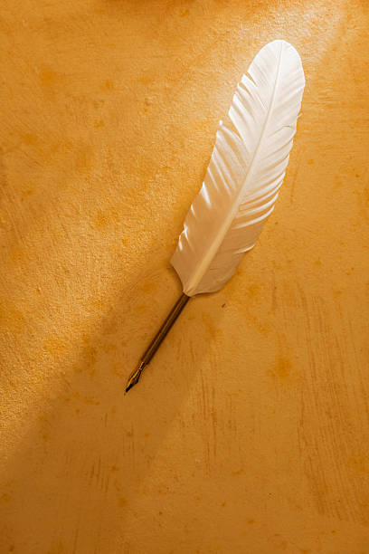 istock White quill pen on old paper 471849513