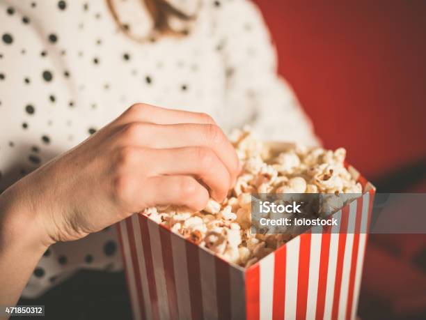 Young Woman Eating Popcorn In Movie Theater Stock Photo - Download Image Now - Popcorn, Movie Theater, Movie