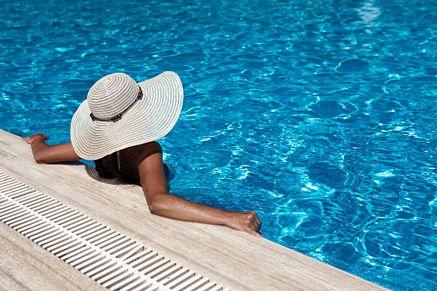 istock Young woman relaxing by the pool 471852459