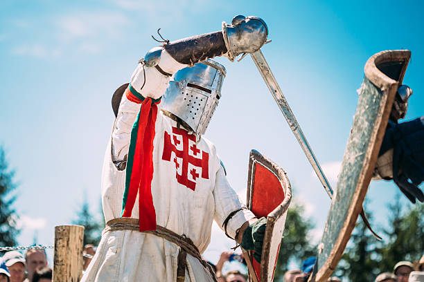 Knights In Fight With Sword. Restoration Of Knightly Battle Dudutki, Belarus - July 19, 2014: Historical restoration of knightly fights on VI festival of medieval culture "Our Grunwald", dedicated to 604 anniversary of Battle of Grunwald chivalry stock pictures, royalty-free photos & images