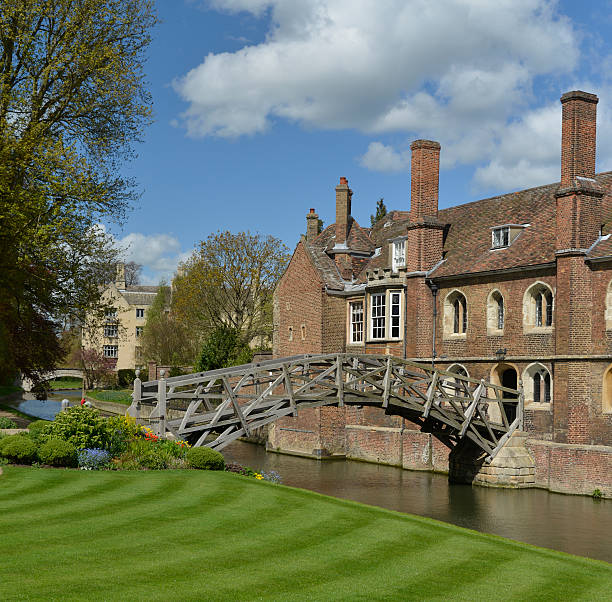 Mathematical bridge Cambridge England. uk. The famous mathematical bridge in the heart of Cambridge England. Taken under a beautiful blue sky with a few white clouds and a lovely newly manicured lawn and gardens. A polorising filter was used to take away some of the glare from the river and add impact and colour. queens college stock pictures, royalty-free photos & images