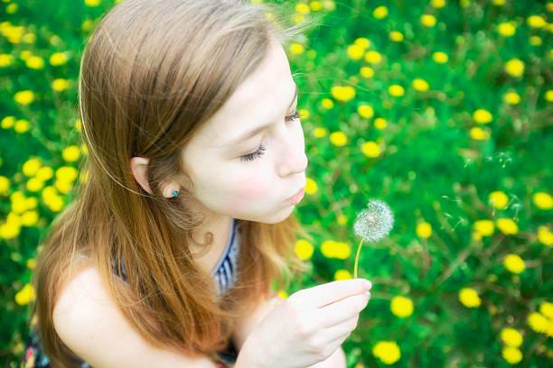 istock Girl with dandelions 471857409