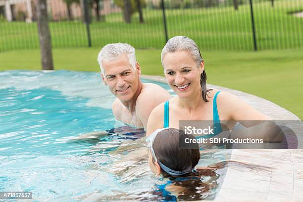 Avós Nadar Na Piscina Com Jovem Neta - Fotografias de stock e mais imagens de Adulto - Adulto, Ao Ar Livre, Atividade Recreativa