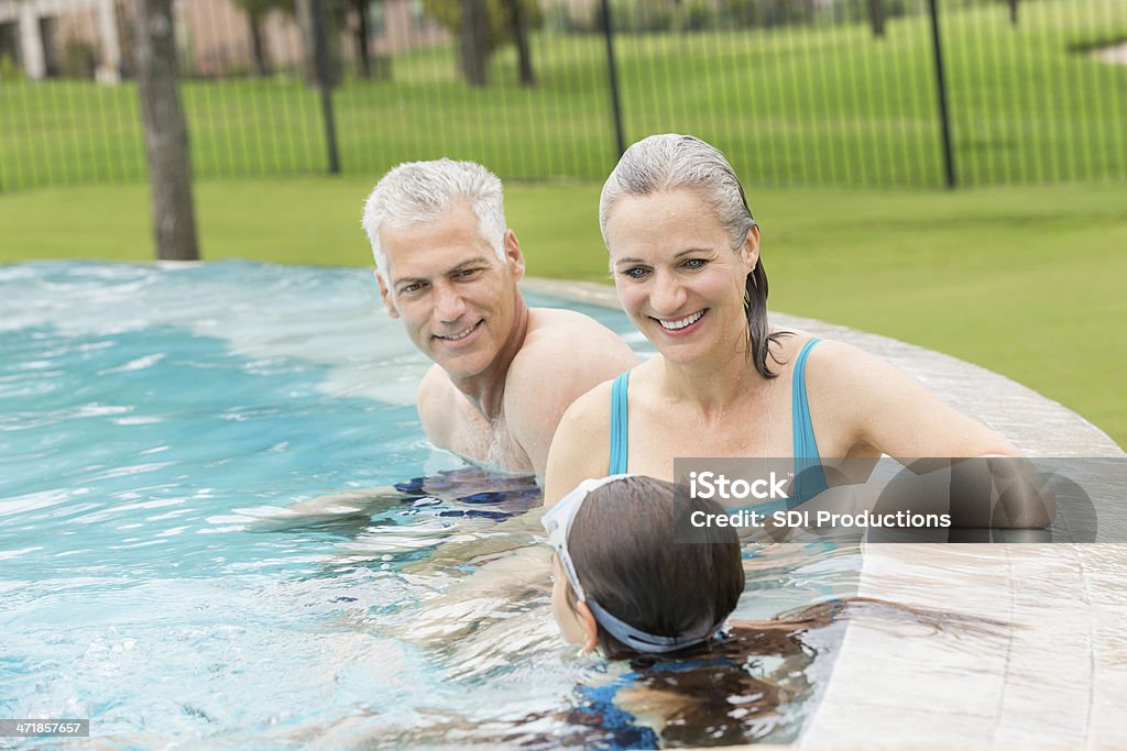 Бабушки и дедушки, плавающие в бассейн с молодой Внучка - Стоковые фото Активный образ жизни роялти-фри