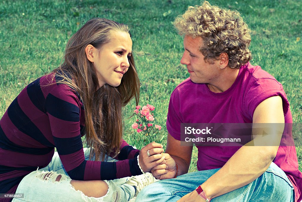 Junger Mann gibt eine Blume zu seiner Freundin - Lizenzfrei Blume Stock-Foto