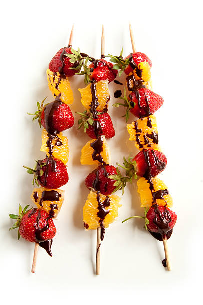 istock Fresh strawberries and orange slices on skewers 471858731