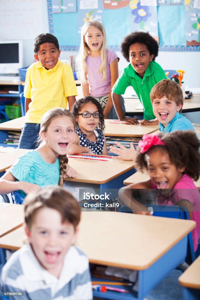 Group of children in classroom Multi-ethnic group of children in elementary school classroom.    Main focus on Hispanic girl wearing eyeglasses (8-9 years). Child Stock Photo