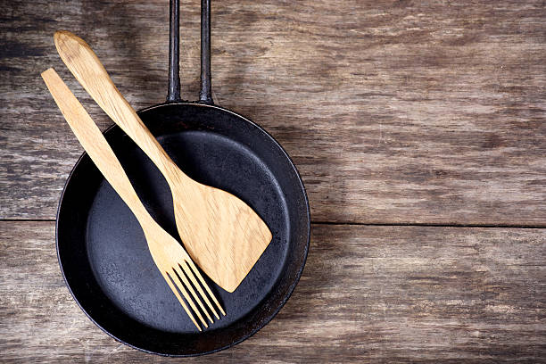 istock Frying pan and kitchen utensils on wooden table 471859996