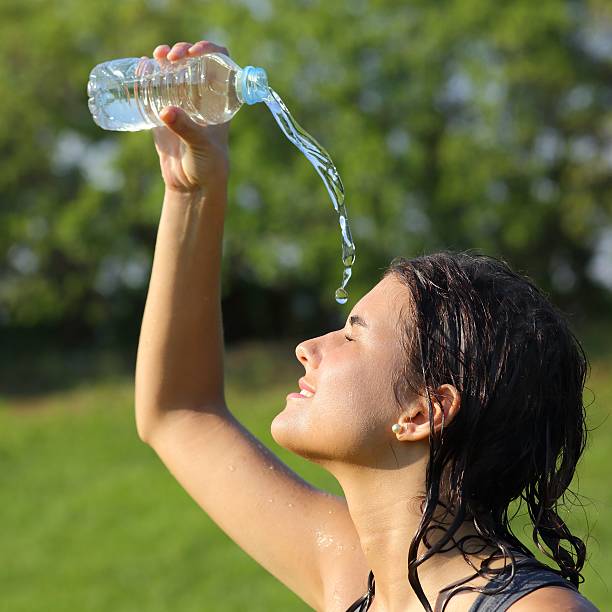istock Beautiful woman throwing herself water from a plastic bottle 471860445