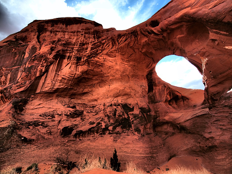 A big rock with window at Monument Valley, which is in North Arizona on the border with Utah. It is Navajo Indian Tribal Park, USA and the tours are managed by Native Americans. HDR filter