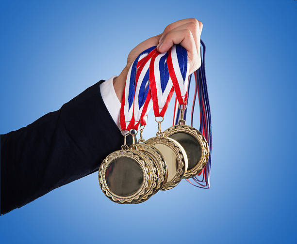 istock Businessman's Hand Holding Medals Over Blue Background 471861618