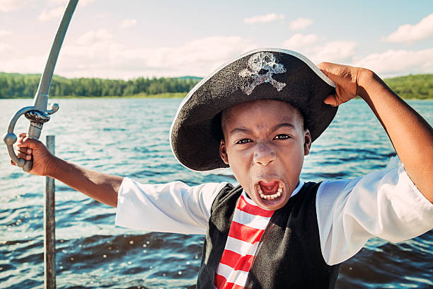 istock Very expressive african-american child dressed as pirate on a lake. 471864633