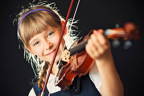 istock Little girl playing the violin 471865529