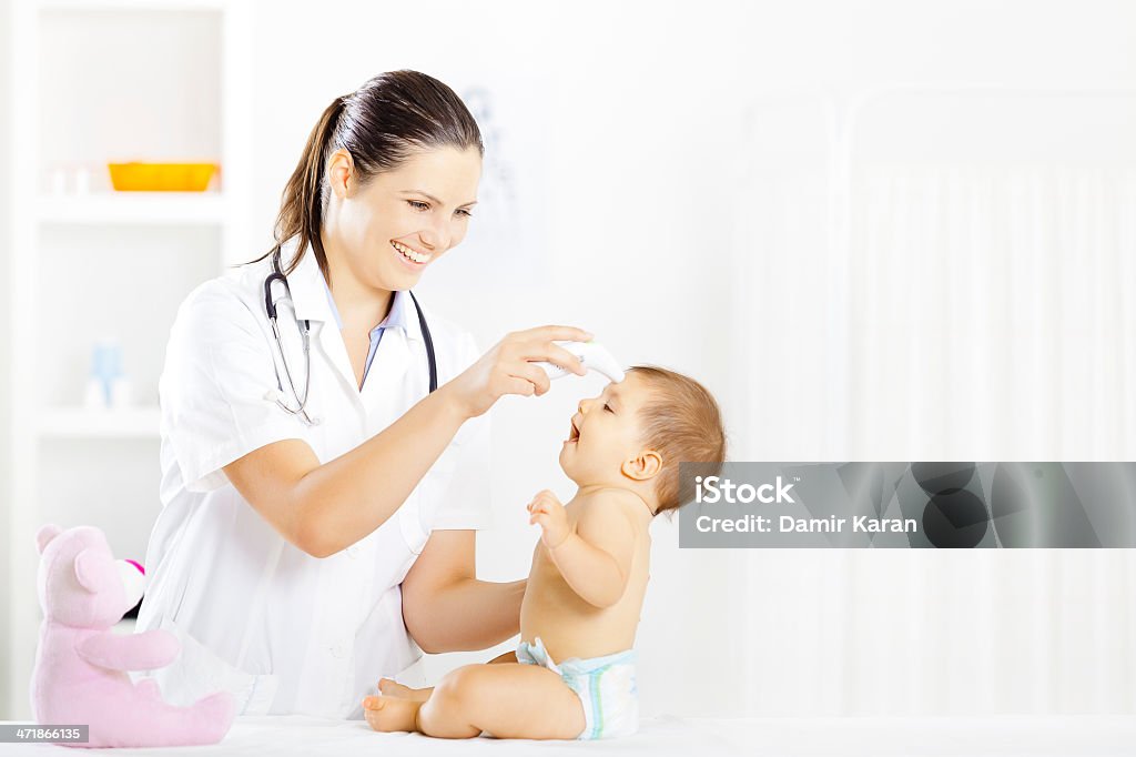 Pediatra con bebé paciente - Foto de stock de 30-34 años libre de derechos