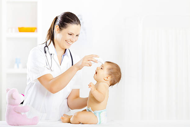 Pediatrician with baby patient stock photo