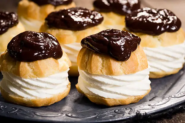 A profiterole or creampuff (in French choux à la crème) is a choux pastry puff ball filled with whipped cream or pastry cream. They are frequently topped with chocolate ganache.
