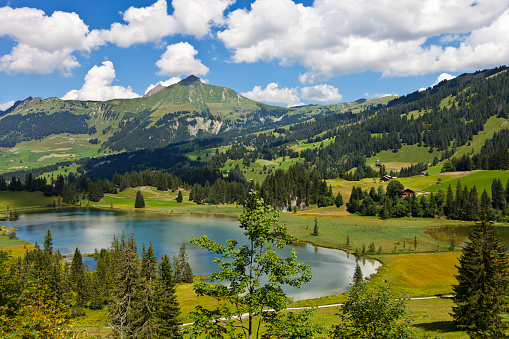 The Lauenensee under a sky with cumulus clouds.