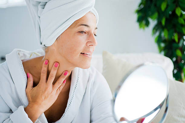 mujer madura y cuidado del cuerpo - touching neck fotografías e imágenes de stock