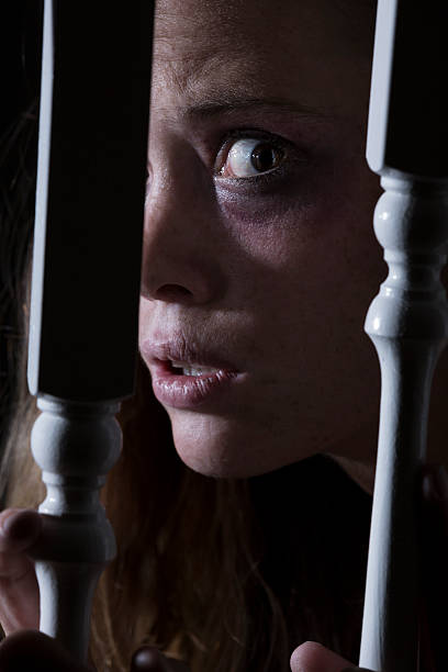 istock Domestic violence: scared abused woman hiding behind the staircase railing 471869151