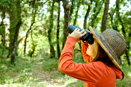 Young child exploring and watching birds with binoculars.