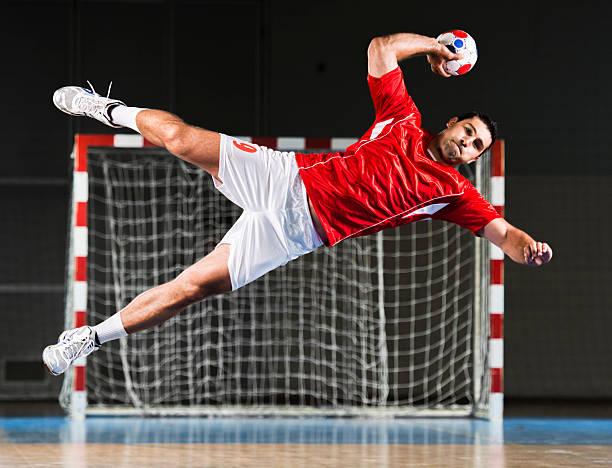 Male handball player in action. Determined handball player in action.   sports uniform photos stock pictures, royalty-free photos & images