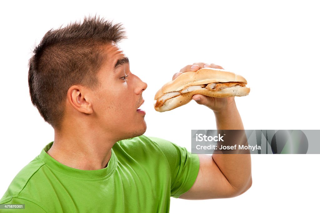 Giovane uomo mangiare Panino - Foto stock royalty-free di 20-24 anni