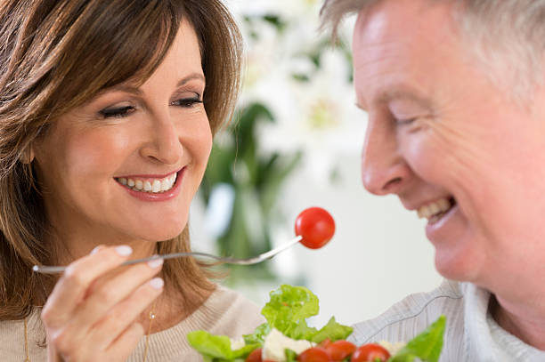 istock Mature woman feeding man salad 471870699