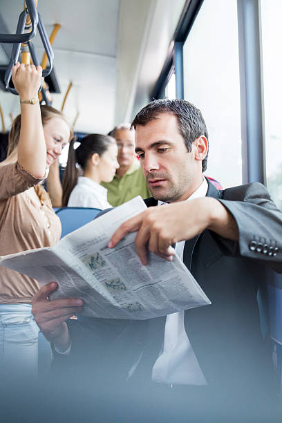 istock Businessman reading newspapers in the bus. 471871523