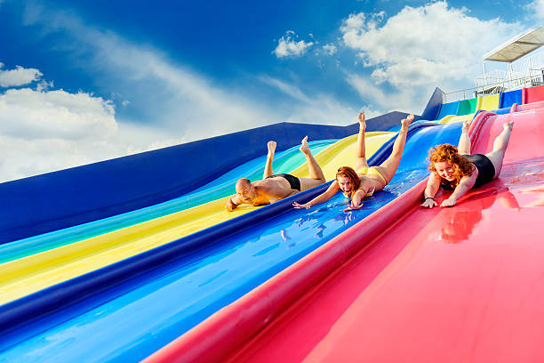 Child on water slide at aquapark. Summer holiday.