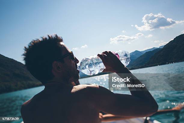 Uomo Beve Da Una Barca - Fotografie stock e altre immagini di 25-29 anni - 25-29 anni, Acqua, Adulto