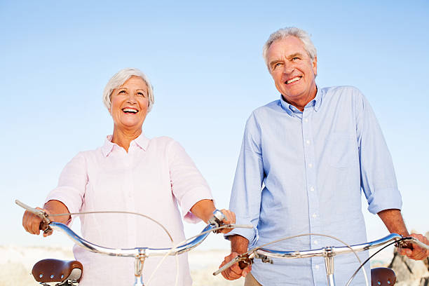 istock Senior Couple With Bicycles Looking Away Against Clear Blue Sky 471874365