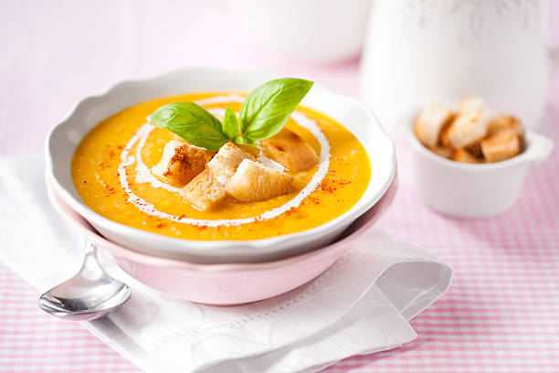 Pumpkin soup with croutons and basil stock photo