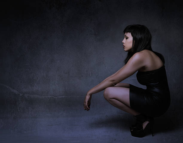 istock girl in a profile side squatting and looking 471875366