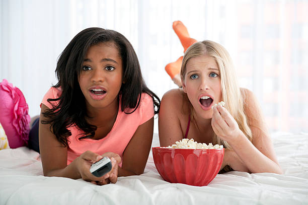 Teens watching television stock photo