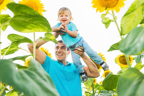 istock Happy father and son among sunflowers. 471878671
