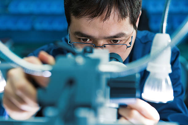 istock Closeup of men with glasses looking at blurred machine 471878757