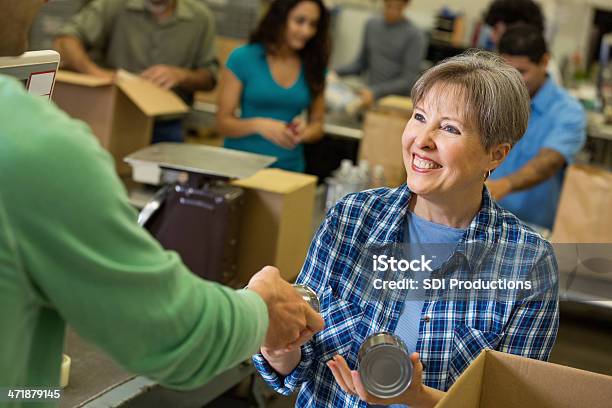 Senior Frau Empfangende Spenden Im Food Bank Sortierung Center Stockfoto und mehr Bilder von Beengt