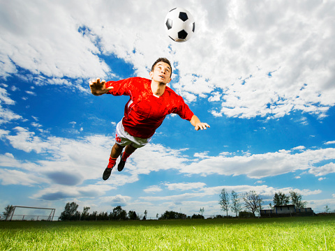 Low angle view of soccer player heading the ball.  