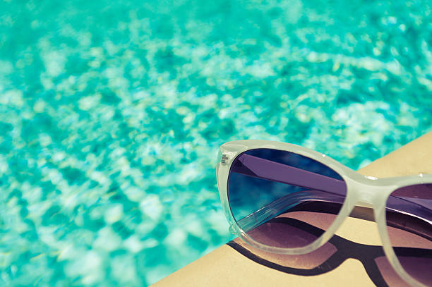 istock Sunglasses beside a swimming pool 471880447