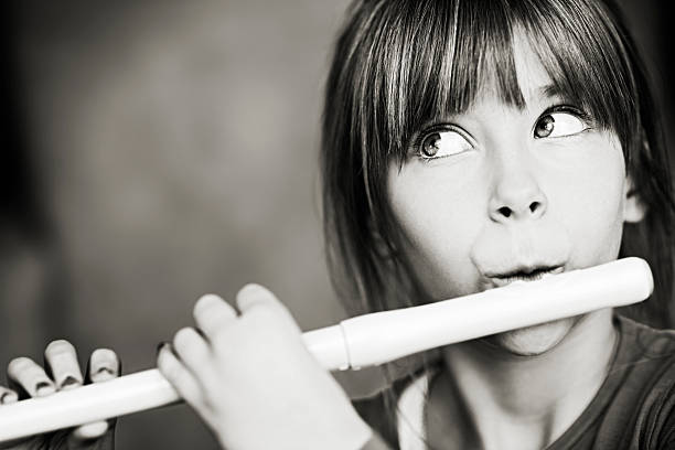 istock Little girl playing flute 471881083