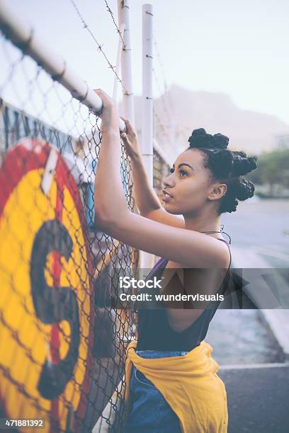 Trespassing Afro Grunge Girl Climbing A Fence Stock Photo - Download Image Now - Adolescence, African Ethnicity, Child