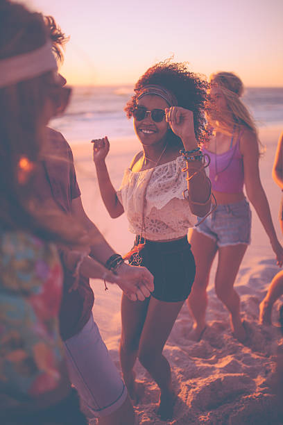 afro chica bailando con sus amigos en una beachparty - beach party friendship teenage girls fotografías e imágenes de stock