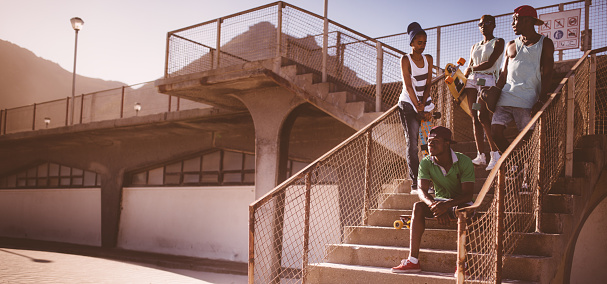 Group of African American longboarders in an urban setting looking cool