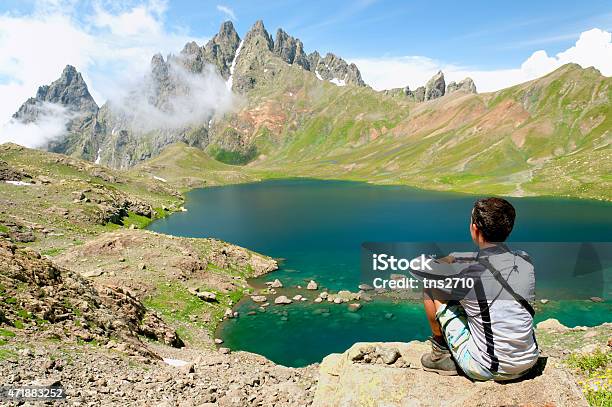 Man Admiring A Beautiful Lake In The Mountains Stock Photo - Download Image Now - 2015, Beach, Blue